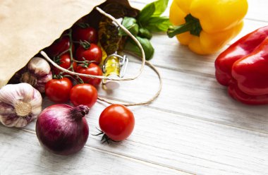 Sağlıklı yemek geçmişi. Kese kağıdında sağlıklı yiyecekler, beyaz ahşap arka planda sebzeler.