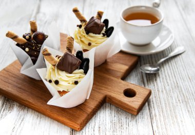 Çikolatalı kekler ve beyaz ahşap arka planda bir fincan çay.