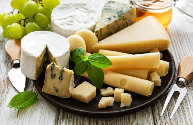 Beyaz ahşap arka planda çeşitli peynir çeşitleri