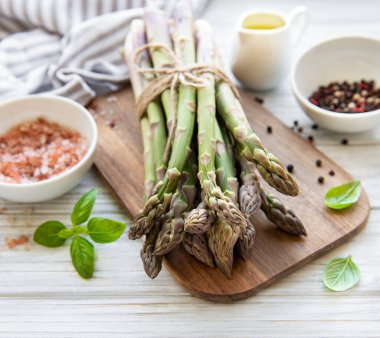 Bir sürü çiğ kuşkonmaz, ahşap zemin üzerinde farklı baharat ve malzemeler barındırır. Üst manzara, düz uzanma.