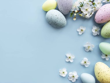 Bahar çiçekleri açan renkli Paskalya yumurtaları mavi arka plan. Renkli Yumurta Tatil Kenarı. 