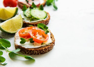 Sağlıklı sebzeli sandviçler ve beyaz arka planda mikro yeşiller.