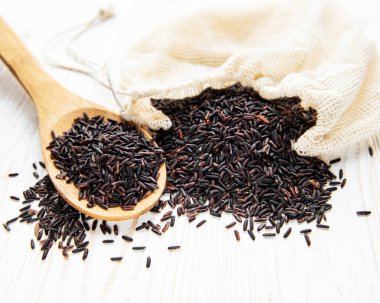 Beyaz ahşap arka planda pişirilmemiş yabani pirinç.