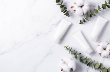 Mermer bir arka planda beyaz krem tüpleri
