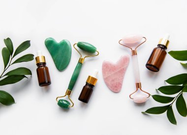 Beyaz arka planda yüz masajı yeşim taşları