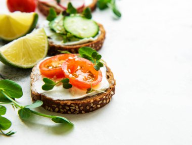 Sağlıklı sebzeli sandviçler ve beyaz arka planda mikro yeşiller.