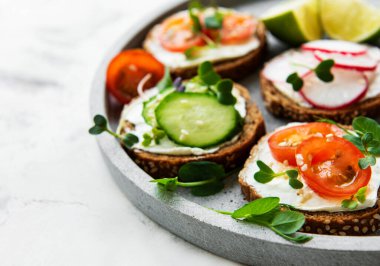 Sağlıklı sebzeli sandviçler ve beyaz arka planda mikro yeşiller.