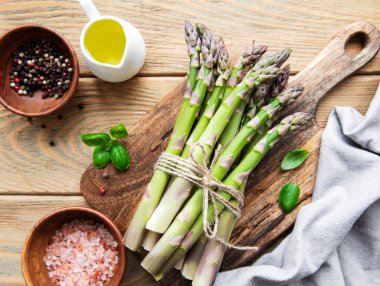 Bir sürü çiğ kuşkonmaz, ahşap zemin üzerinde farklı baharat ve malzemeler barındırır. Üst manzara, düz uzanma.