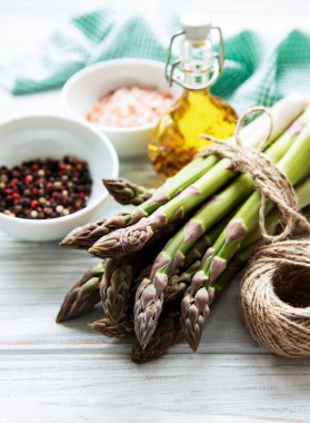 Bir sürü çiğ kuşkonmaz, ahşap zemin üzerinde farklı baharat ve malzemeler barındırır. Üst manzara, düz uzanma.