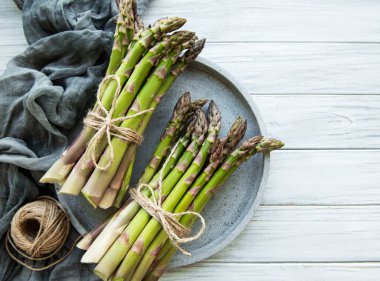 Ahşap arka planda bir sürü çiğ kuşkonmaz var. Üst manzara, düz uzanma.