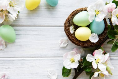 Ahşap arka planda bahar çiçekleri olan renkli Paskalya yumurtaları. Renkli Yumurta Tatil Kenarı. 