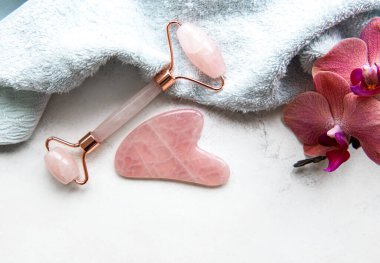 Güzellik masajı terapisi için yeşim yüz silindiri. Wtite havlu arka planında düz uzandı