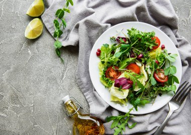 Taze yeşil salata kasesi, domatesli ve çimento kaplı mikroyeşillikler. Sağlıklı yemek, en iyi manzara..