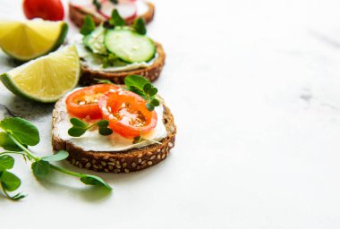 Sağlıklı sebzeli sandviçler ve beyaz arka planda mikro yeşiller.