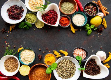 Siyah beton arka planda bir kasede çeşitli baharatlar. Üst görünüm kopyalama alanı.