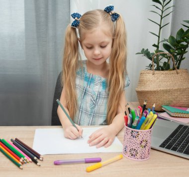 Evdeki odasında ödev yapan tatlı bir kız.