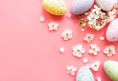 Pembe arka planda bahar çiçekleri olan renkli Paskalya yumurtaları. Renkli Yumurta Tatil Kenarı. 