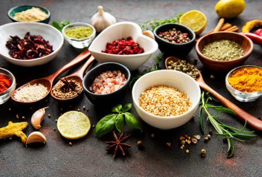 Siyah beton arka planda bir kasede çeşitli baharatlar. Üst görünüm kopyalama alanı.