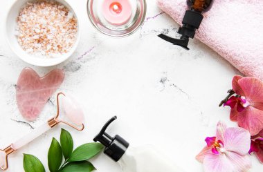 Beyaz mermer arka planda kozmetik ürünü ile yüz masajı yeşim silindiri