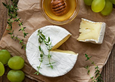 Camembert peyniri ve eski ahşap masada atıştırmalıklar.