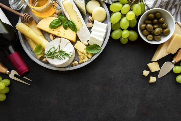 Çeşit çeşit peynir, üzüm, şarap ve abur cuburlar.