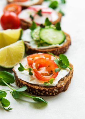 Sağlıklı sebzeli sandviçler ve beyaz arka planda mikro yeşiller.