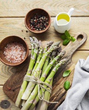 Bir sürü çiğ kuşkonmaz, ahşap zemin üzerinde farklı baharat ve malzemeler barındırır. Üst manzara, düz uzanma.