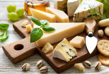 Beyaz ahşap arka planda çeşitli peynir çeşitleri