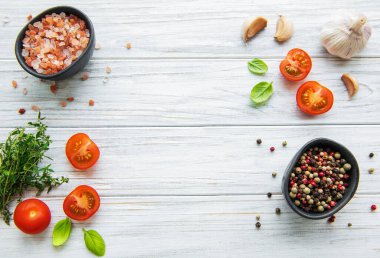 Beyaz ahşap arka planda sarımsaklı domates, fesleğen ve biber.