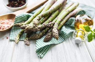 Bir sürü çiğ kuşkonmaz, ahşap zemin üzerinde farklı baharat ve malzemeler barındırır. Üst manzara, düz uzanma.