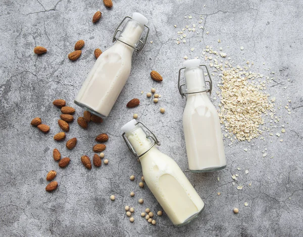 Bottles with different plant milk - soy, almond and oat milk.