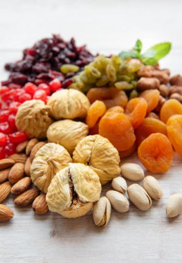 Ahşap arka planda çeşitli kurutulmuş meyve ve fındıklar.