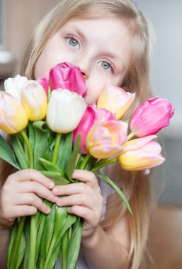 Küçük bir kızın ellerinde bahar laleleri. Anneler günü hediyesi..