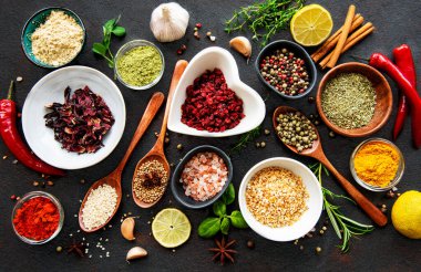 Siyah beton arka planda bir kasede çeşitli baharatlar. Üst görünüm kopyalama alanı.