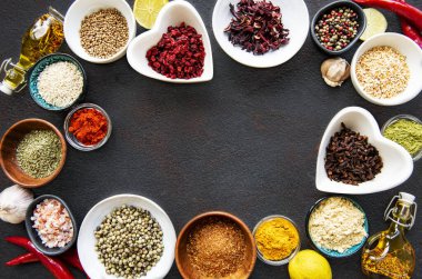 Siyah beton arka planda bir kasede çeşitli baharatlar. Üst görünüm kopyalama alanı.