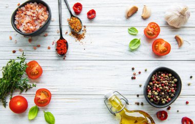 Beyaz ahşap arka planda sarımsaklı domates, fesleğen ve biber.