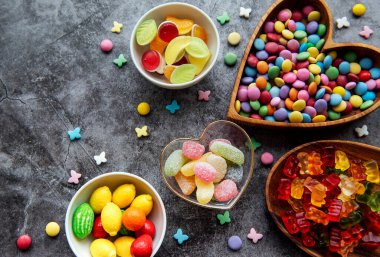 Siyah arka planda çok renkli şekerler, cereyanlar ve jöle.