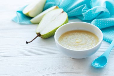 Bebek mamaları ve armutlarla dolu bir kase.