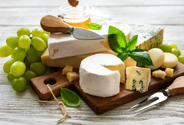 Beyaz ahşap arka planda çeşitli peynir çeşitleri
