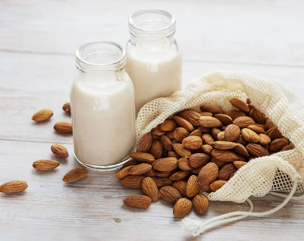 Flaschen Mit Mandelmilch Und Mandeln Auf Dem Tisch — Stockfoto