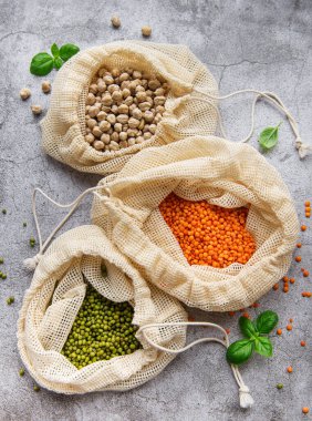 Kahverengi arka planda farklı tipte baklagiller bulunan eko torbalar