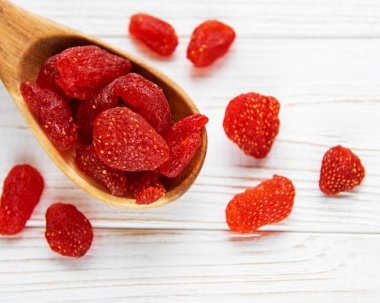 Eski bir arka planda kaşık içinde kurutulmuş çilek. 