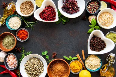 Siyah beton arka planda bir kasede çeşitli baharatlar. Üst görünüm kopyalama alanı.