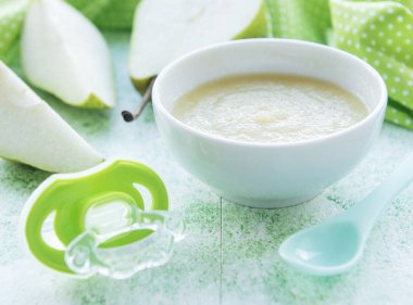 Bebek mamaları ve armutlarla dolu bir kase.