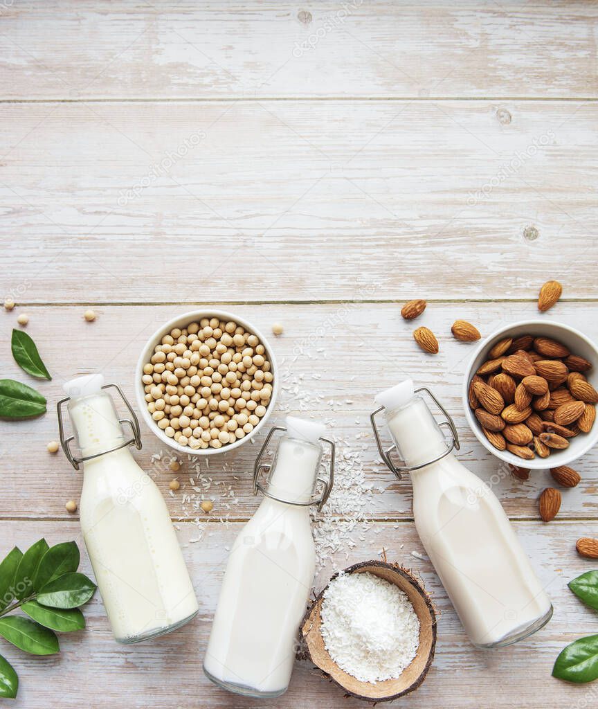 Bottles with different plant milk - soy, almond and oat milk.