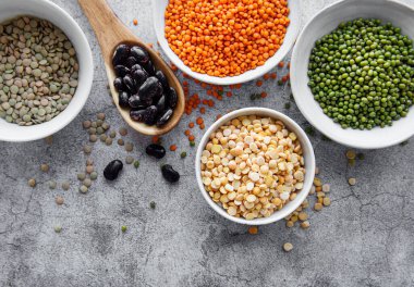 Gri beton arka planda farklı tipte baklagiller.