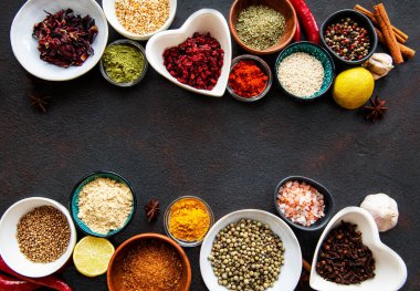 Siyah beton arka planda bir kasede çeşitli baharatlar. Üst görünüm kopyalama alanı.