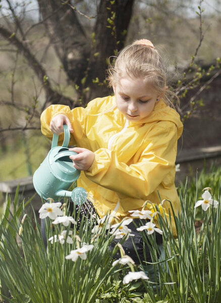 Маленькая девочка в саду с зеленой кастрюлей