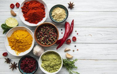 Beyaz ahşap arka planda çeşitli baharatlar, üst görünüm