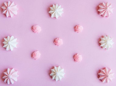 Merengue arka planı. Düz yatıyordu. Üst Manzara. Pembe arka planda ev yapımı tatlı merengue.